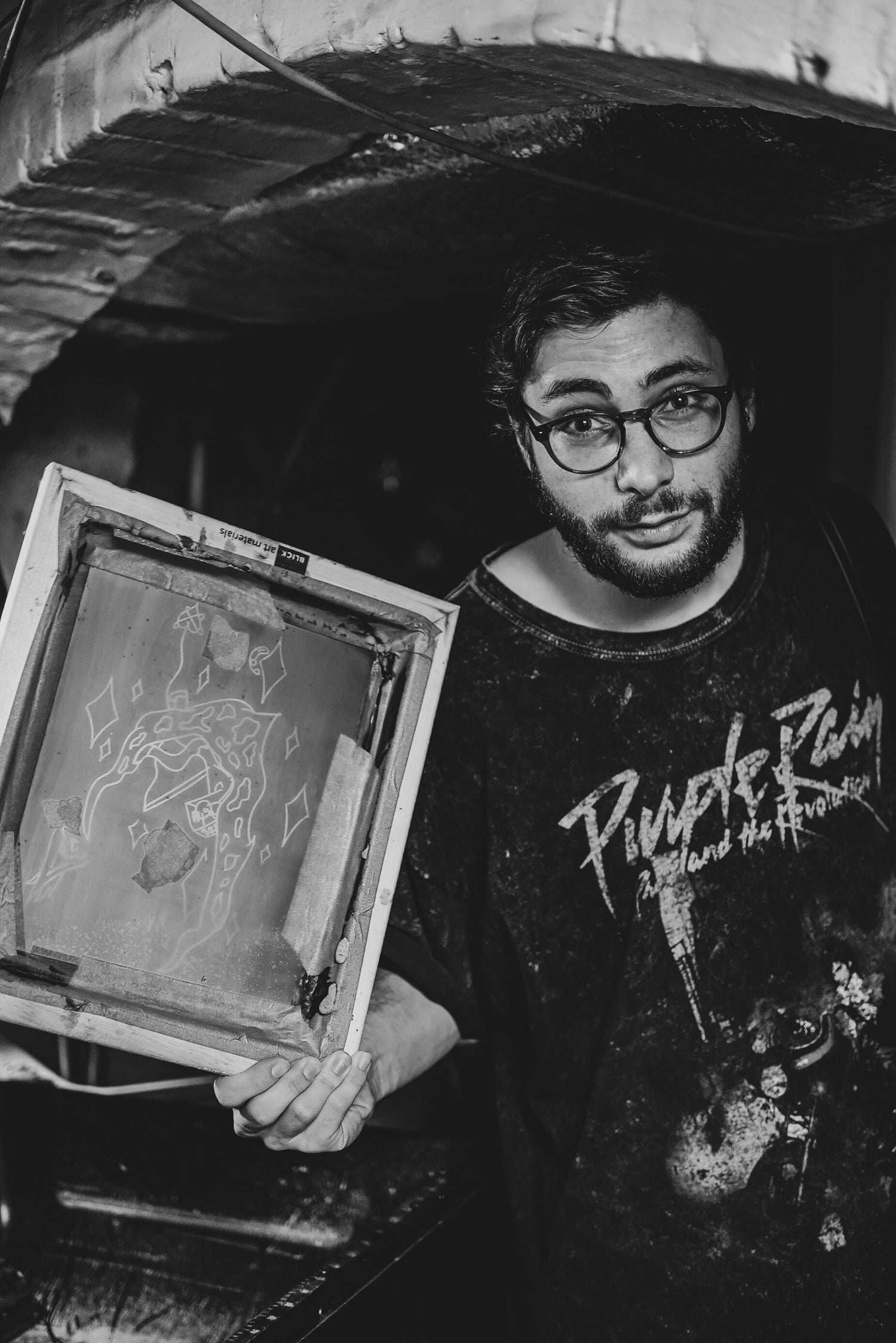 Phil Deutsch in his home studio in Manhattan, holding a handmade silk screen